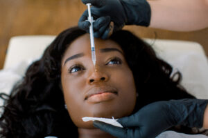Woman receiving an injectable cosmetic treatment in her bunny lines (nose).