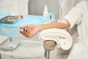 Image of the arm of a woman receiving an IV treatment.